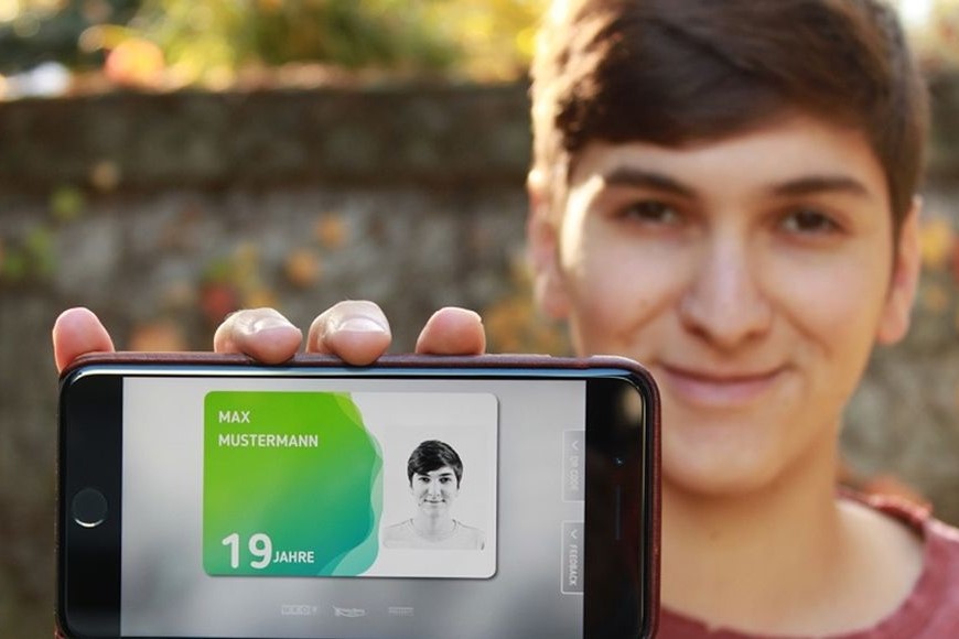 Junger Bursch zeigt seine aha card im App auf seinem Handy