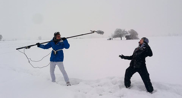 Jugendliche im Schnee mit Stabmikrofon