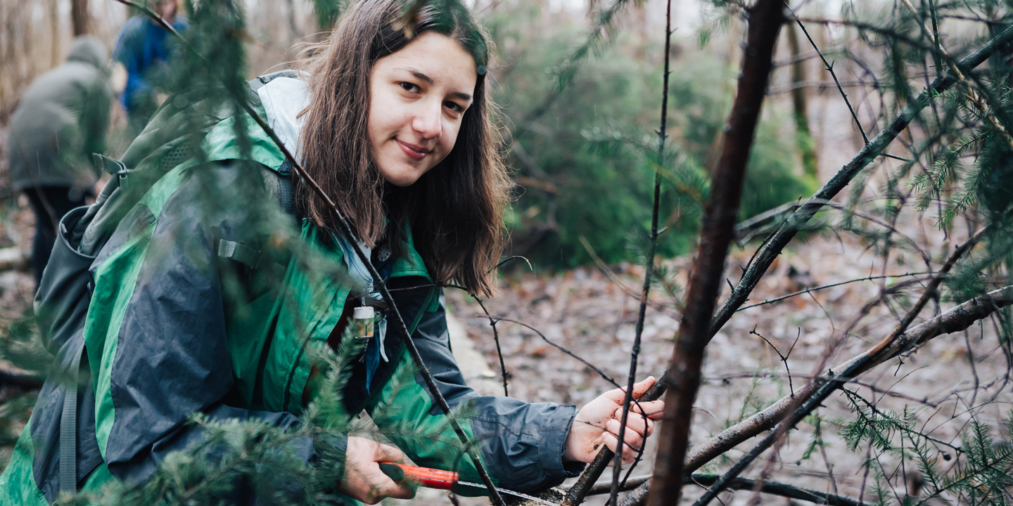 Jugendliche im Wald bei Holzarbeiten-