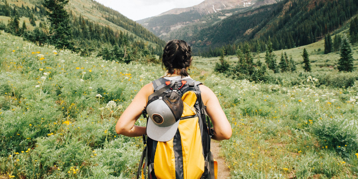 Jguendliche mit gelben Wanderucksack in de NAtur