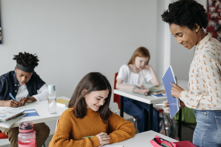 Lehrerin mit Schüler*innen in einem Klassenzimmer