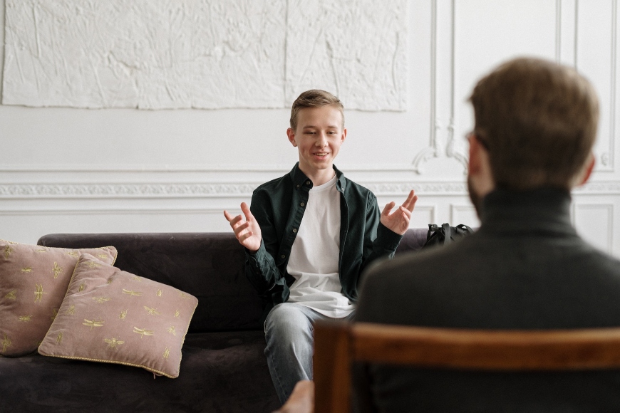 Junge sitzt auf Couch bei Beratung