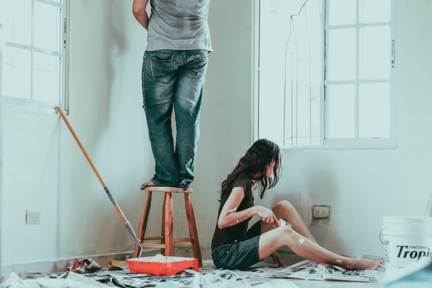 Zwei Personen, die ein Zimmer streichen