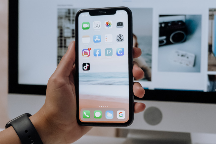 Man sieht ein Smartphone mit verschiedenen Apps, wie z. B. Instagram, TikTok, WhtasApp usw.