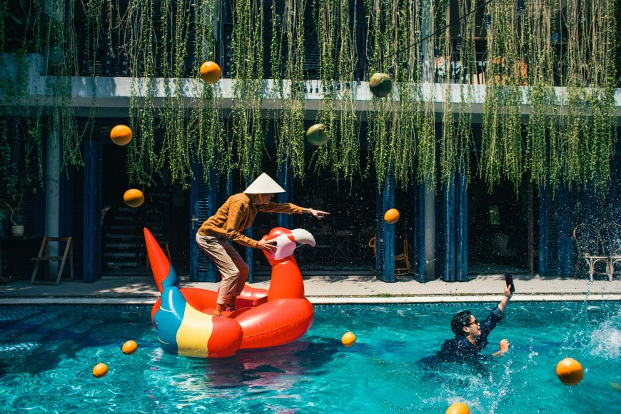 Eine Person steht in auf einem aufblasbaren Tier und lässt sich in einem Pool von jemandem ziehen.