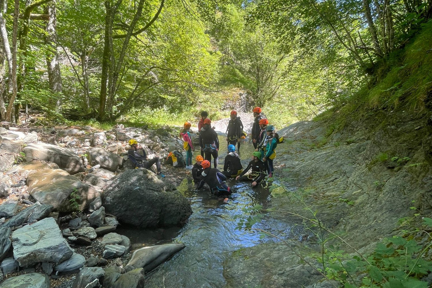 Jugendliche beim Canyoning im Wald.